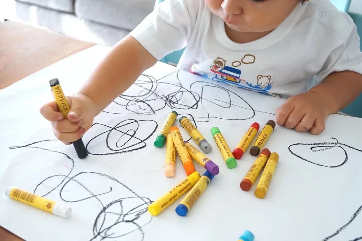 Niño coloreando con negro sobre el papel, reflejando su mundo emocional